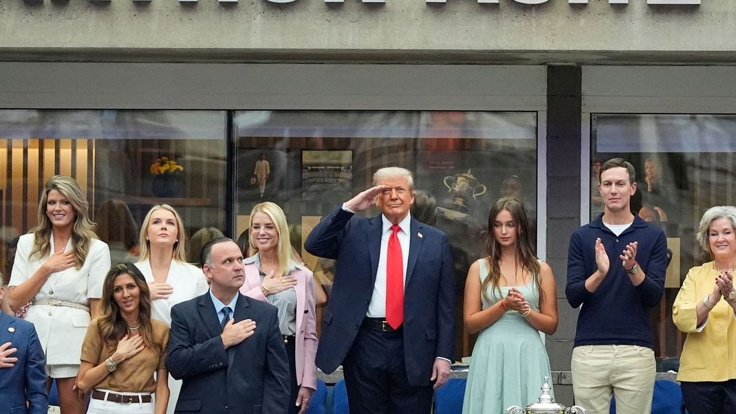 Präsident Donald Trump (Mitte) und andere erheben sich für die Nationalhymne vor dem Finale der US-Open im Herren-Einzel am Sonntag, den 7. September 2025.
