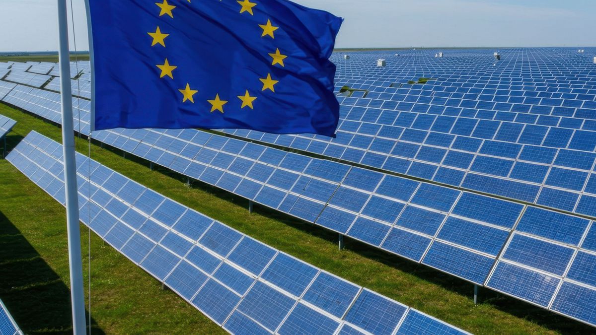 Aerial View of Extensive Solar Panel Fields under the European Union Flag Representing Sustainable Energy