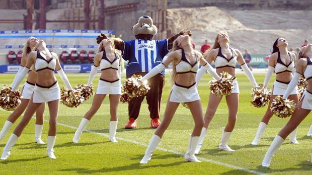 
                <strong>Hertha BSC</strong><br>
                Hier tanzt das Maskottchen von Hertha BSC, "Herthinho", mit den Cheerleaderinnen des damaligen NFL-Europe-Klubs Berlin Thunder auf dem Spielfeld. Eine eigenen Cheerleader-Truppe haben die Berliner aber nicht.
              
