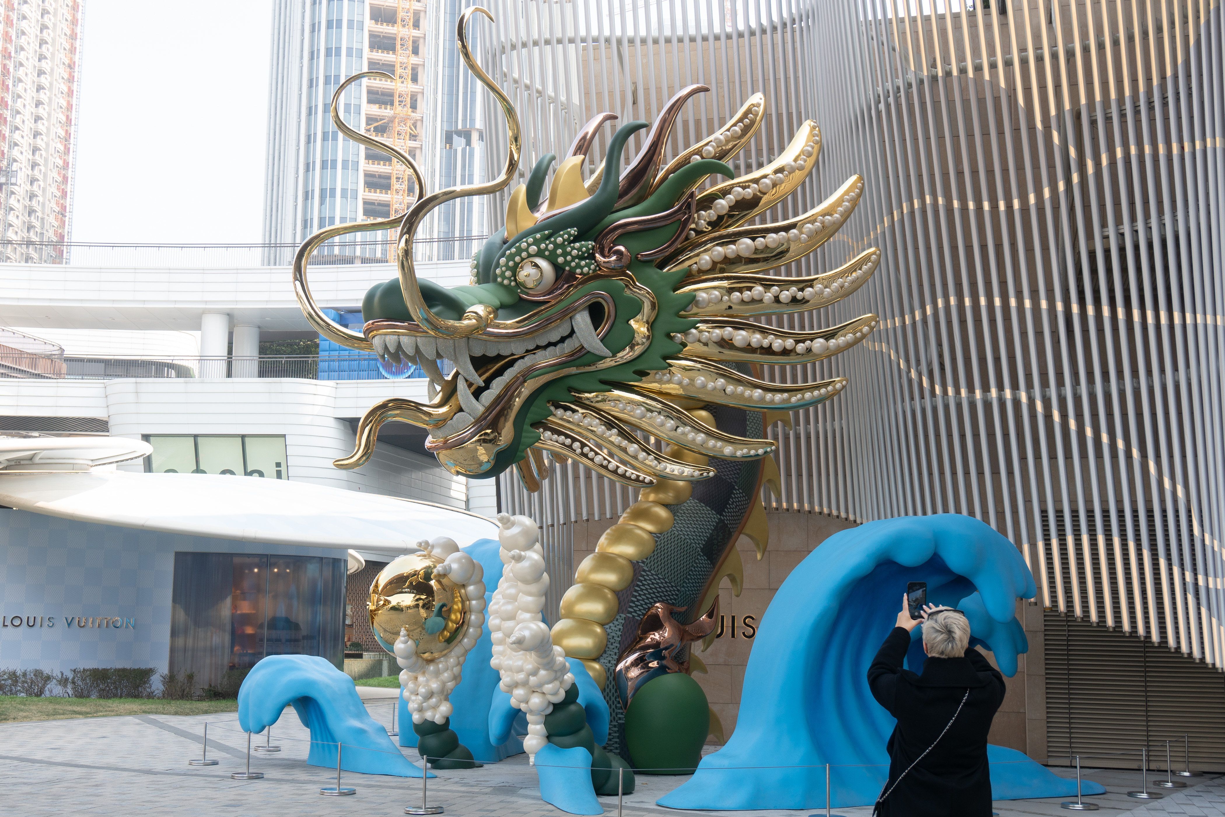 Gold-grüne Drachenstatue am Eingang eines Geschäfts in Shanghai, China.