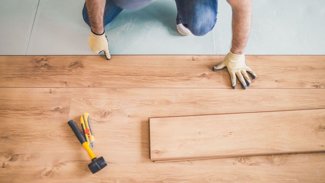 Heimwerker verschönert sich den Wohnraum mit einen Laminatboden.