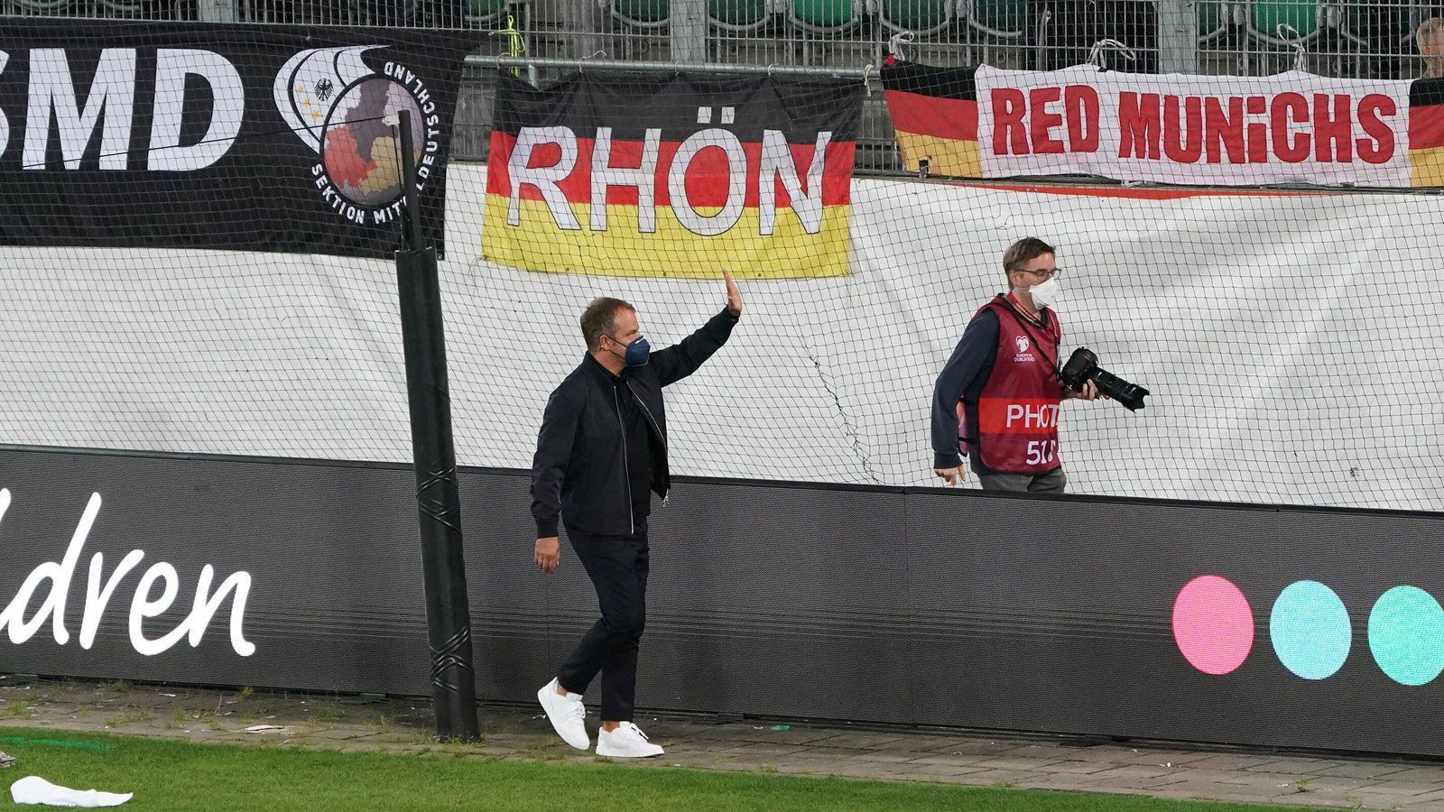 
                <strong>Hansi Flick bei seinem Bundestrainer-Debüt</strong><br>
                Vor Anpfiff sucht der frisch gepuderte Flick die Nähe zu den Fans, winkt artig ins Publikum. Die Spannung steigt. Wie wird der Neustart ausfallen?
              