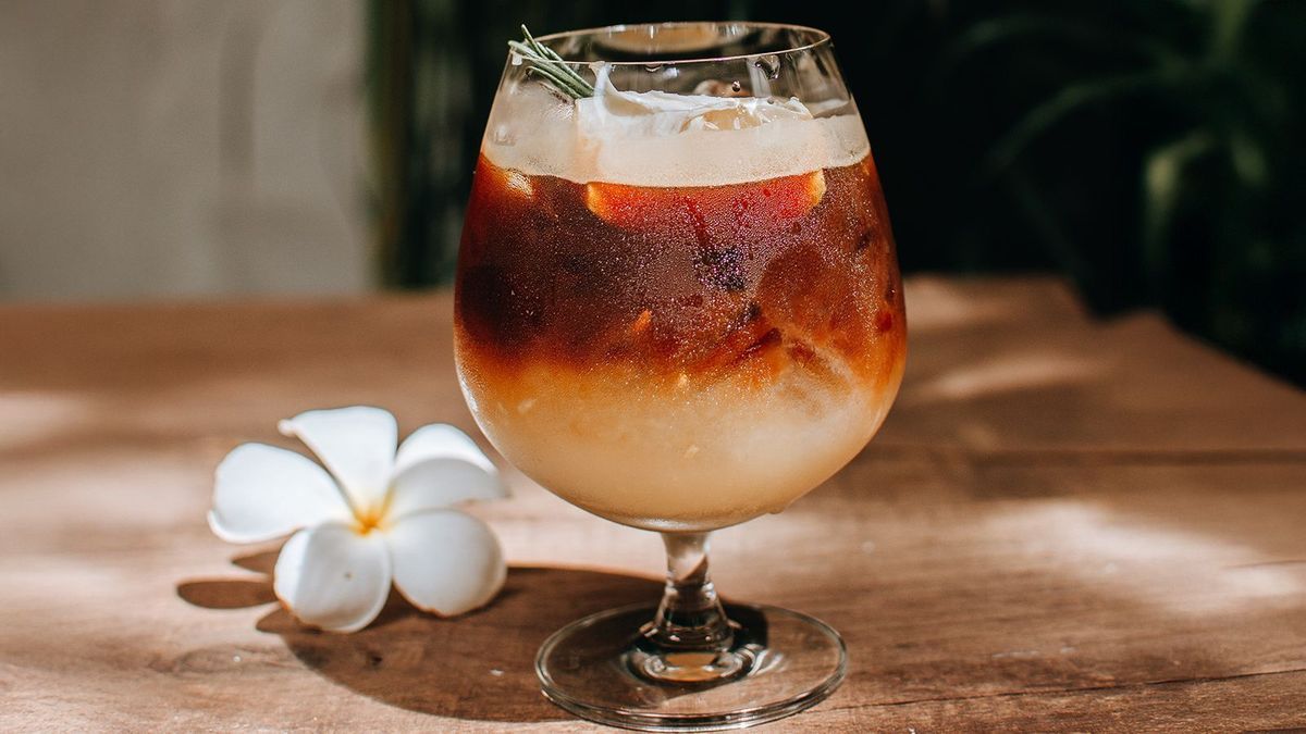 Iced yuzu orange espresso coffee mocktail cold brew tonic spritz on wooden background, Concept menu for coffee shop.