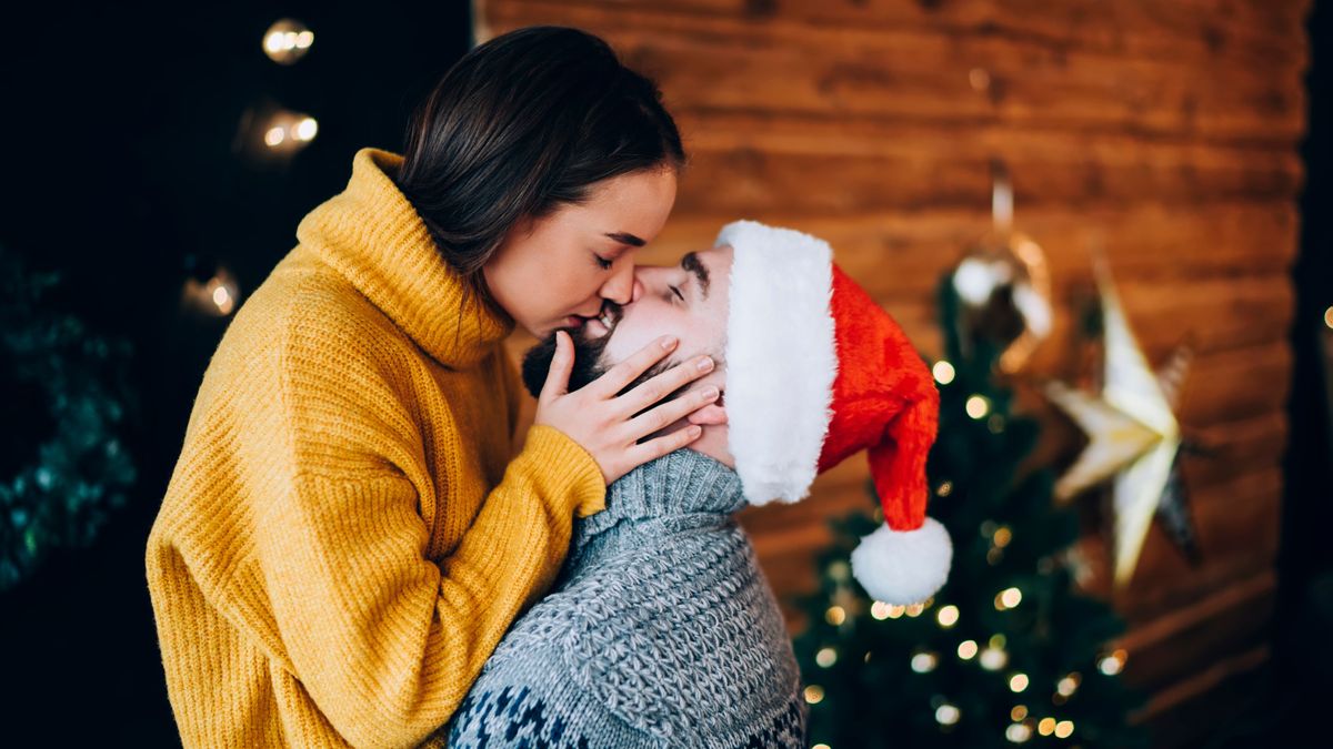 Loving young couple kissing in new year studio