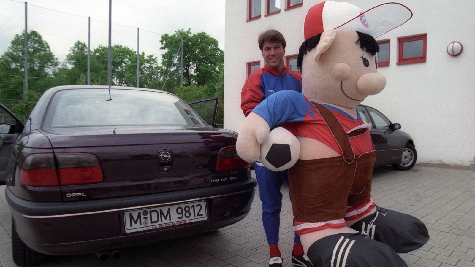 
                <strong>FC Bayern München: Die Maskottchen im Wandel der Zeit</strong><br>
                Schon zwei Jahre später sah Bazi deutlich knuffiger aus. Hier macht er sich für einen Roadtrip mit Lothar Matthäus fertig.
              