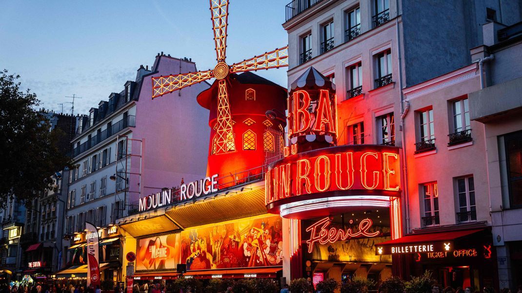 Normalerweise erstrahlt das Theater Moulin Rouge, das in Form einer Windmühle errichtet wurde, mit seinen Flügeln ganz in Rot und zieht jährlich Millionen Besucher:innen an.&nbsp;