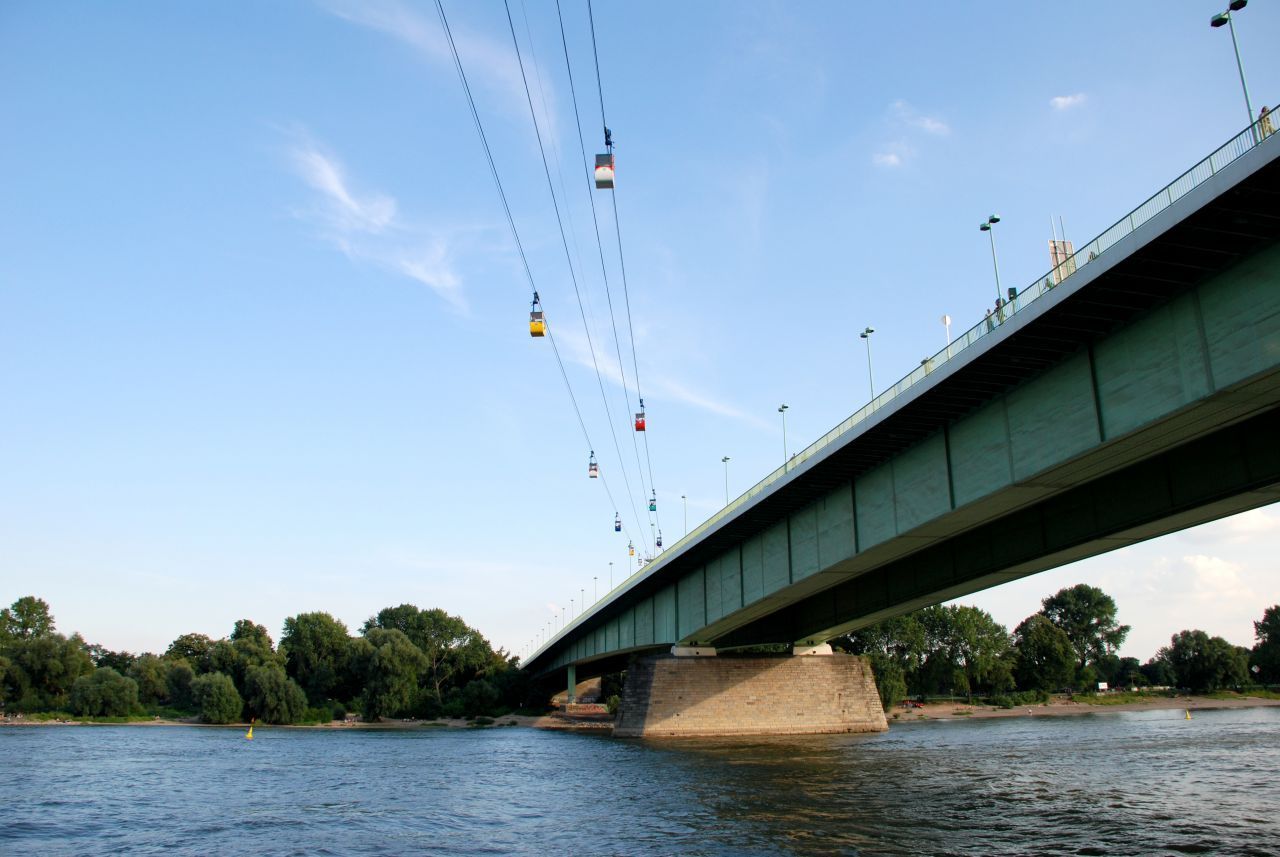 1957 nahm die damalige Rheinseilbahn den Betrieb auf. Heute heißt sie einfach Kölner Seilbahn, verbindet aber immer noch über 930 Meter die beiden Flussufer zwischen Zoo und Rheinpark. Eine Fahrt dauert 6 Minuten, und schon über 20 Millionen Menschen sollen in ihr über den Rhein gegondelt sein. 