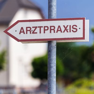 Ein Schild "Arztpraxis" steht an einer Straße in Wustermark in Brandenburg.