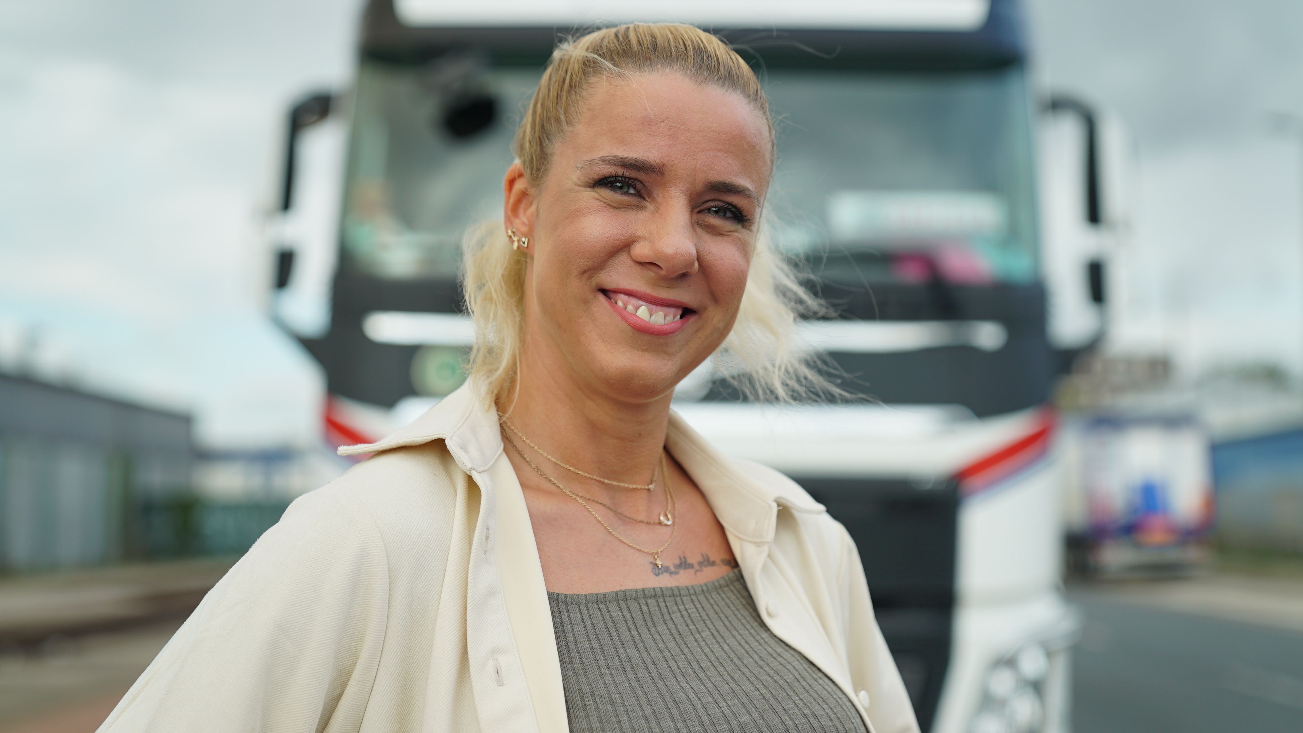Vor dem Truck steht "Trucker Babe" Daniela und ihr schwerer Truck befindet sich im Hintergrund.
