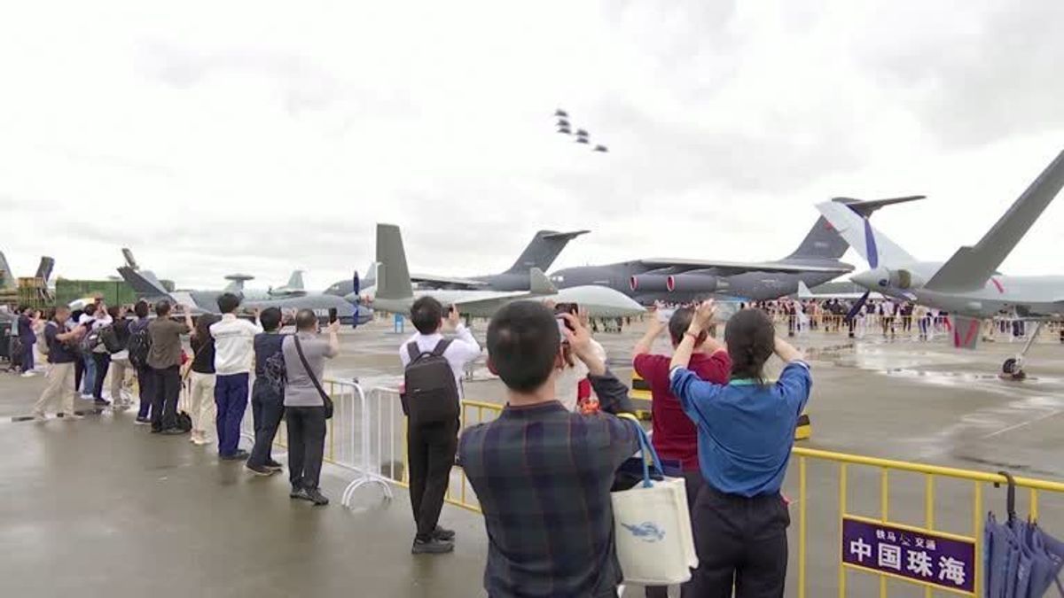 Archivaufnahme: Besucher:innen der chinesischen Luftfahrtausstellung in Zhuhai beobachten die neuen Militär-Kampfjets. 