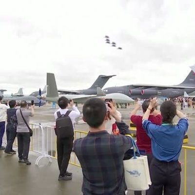 Archivaufnahme: Besucher:innen der chinesischen Luftfahrtausstellung in Zhuhai beobachten die neuen Militär-Kampfjets. 