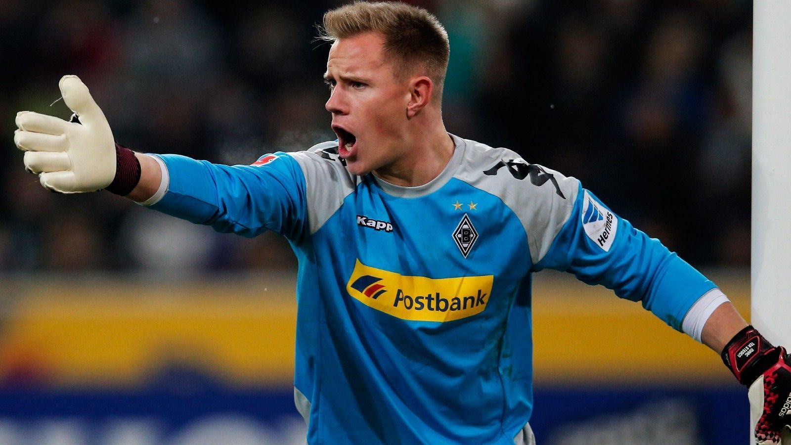 
                <strong>Torwart: Marc-Andre ter Stegen</strong><br>
                Ein "Gladbacher Junge" durch und durch. Schon im Alter von vier Jahren schließt sich Marc-Andre ter Stegen der Borussia aus Mönchengladbach an, durchläuft sämtliche Jugendteams und bekommt dann vom damaligen Fohlen-Coach Lucien Favre die Chance, sich in der deutschen Beletage zu beweisen. Sein Bundesliga-Debüt: Am 10. April 2011 gegen den 1. FC Köln. Ausgerechnet das Derby. Doch der "Mini-Kahn", wie ter Stegen aufgrund seiner impulsiven und ehrgeizigen Art genannt wird, nutzt seine Chance und wird nicht nur zum großen Rückhalt seiner Borussia, sondern in kürzester Zeit zu einem der besten Keeper der Welt - kein Wunder, dass ihn sein Weg zur Saison 2014/2015 zum großen FC Barcelona führte, wo er heute unangefochtener Stammkeeper ist. Unter Tränen verabschiedete sich ter Stegen damals von "seinen" Fans im Borussia-Park und schaut auch heute noch so oft es seine Zeit zulässt, an der Hennes-Weisweiler-Allee vorbei.
              