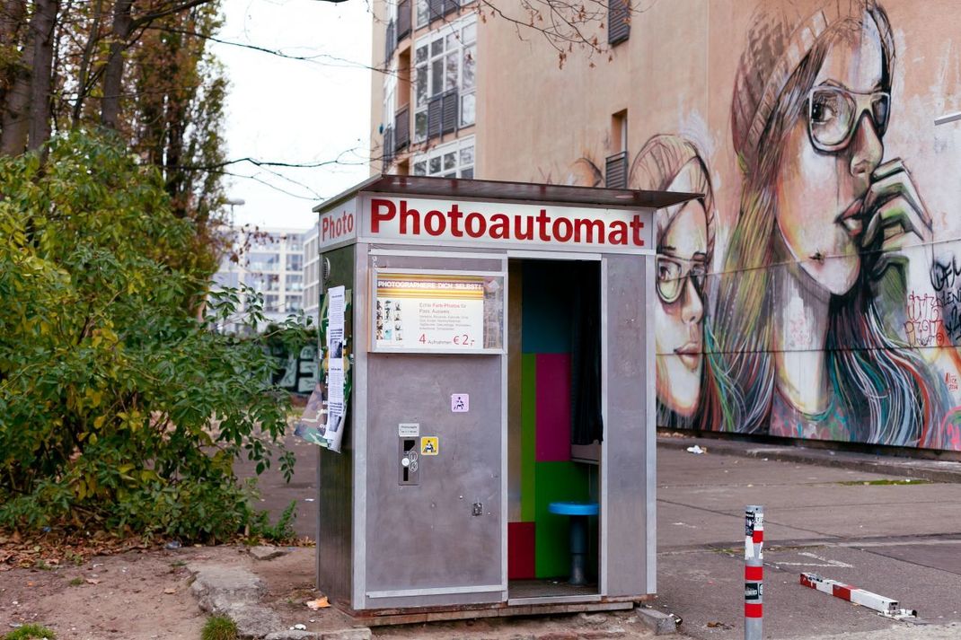 Der Franzose Ernest Enjalbert soll 1889 den ersten funktionsfähigen Fotoautomat entwickelt haben. Der wurde auf der Pariser Weltausstellung vorgeführt. Das alte Exemplar im Bild steht in Berlin-Friedrichshain.