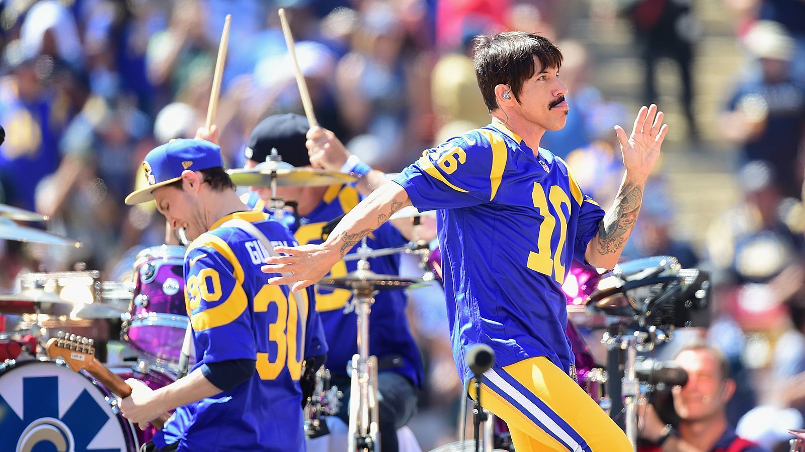 <strong>Red Hot Chili Peppers (Los Angeles Rams)</strong><br>
                Die Herzen der Red Hot Chili Peppers schlagen für die Los Angeles Rams. Die Rocker aus der kalifornischen Metropole performten vor dem ersten Heimspiel des Teams in der Stadt der Engel im L.A. Coliseum - und zwar in den Trikots von Jared Goff und Todd Gurley.
