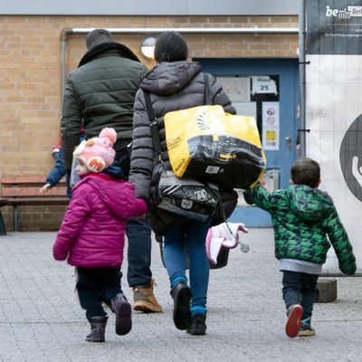 Ein Flüchtling geht mit seiner Familie auf dem Gelände der Erstaufnahmeeinrichtung des Landesamtes für Flüchtlingsangelegenheiten in Berlin. 