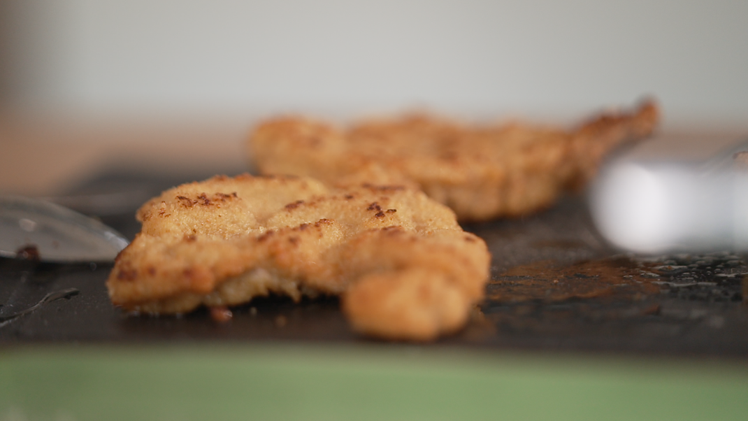 Damit die Panade besonders knusprig wird, hilft es, das Schnitzel vor dem Panieren anzufeuchten.