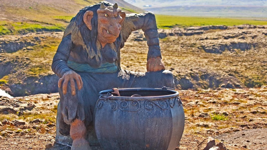 Die Nachbildung eines Trolls sitzt in isländischer Natur