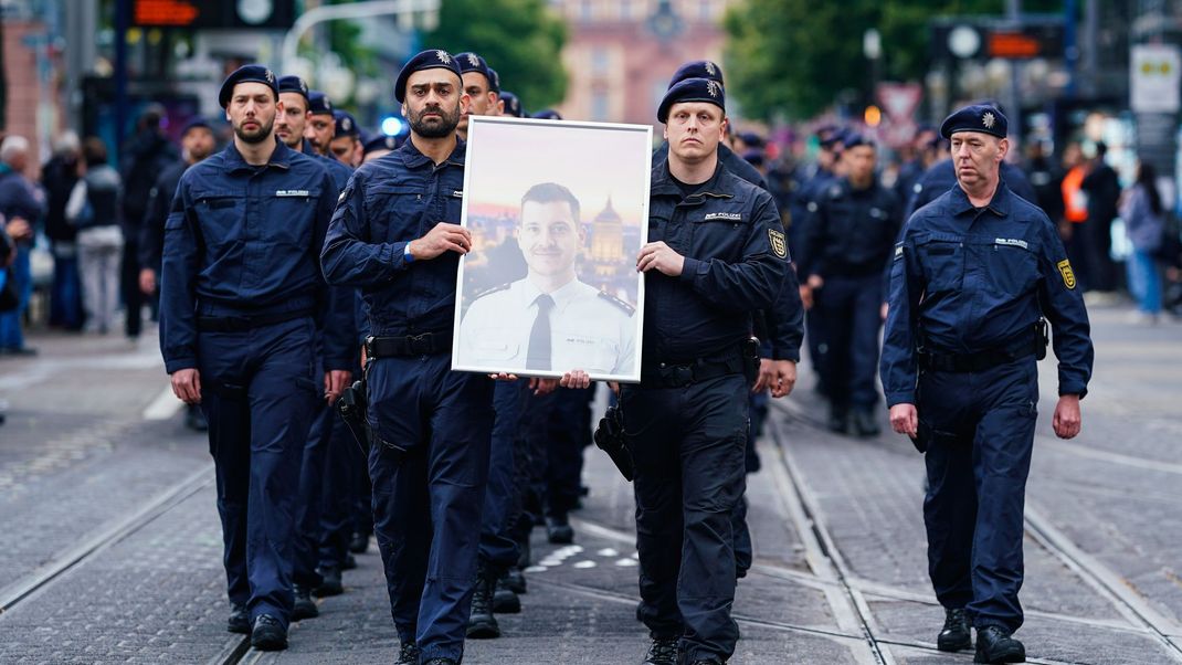 Polizeibeamte tragen das Bild des getöteten Rouven L.