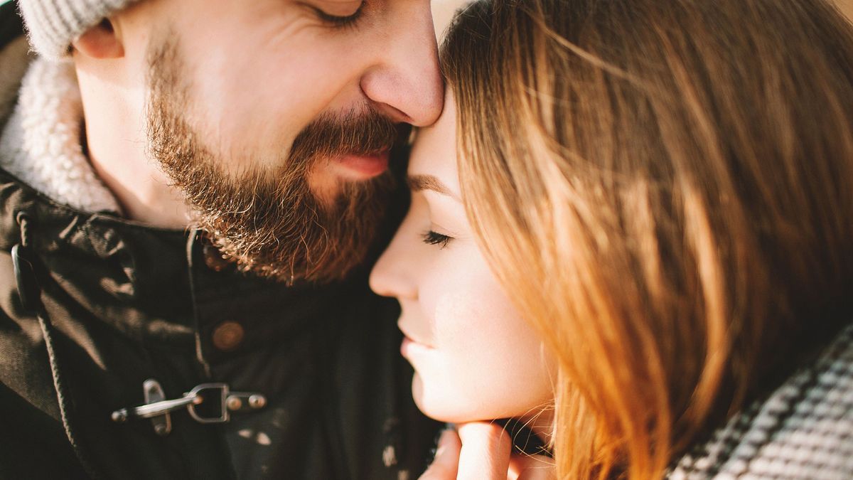 Close-up portrait of hipster couple hugging with closed eyes