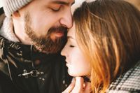 Close-up portrait of hipster couple hugging with closed eyes