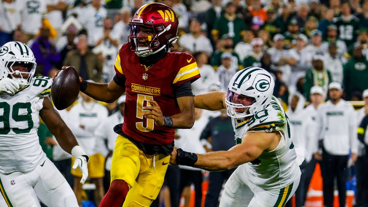 Washington Commanders quarterback Jayden Daniels (L) scrambles away from Green Bay Packers defensive end Lukas Van Ness (R) in the second half of the NFL, American Football Herren, USA game between...