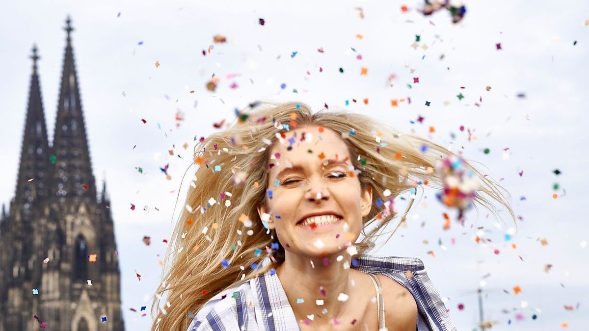 FMKF04742 - Germany, Cologne, portrait of happy blond woman in between shower of confetti