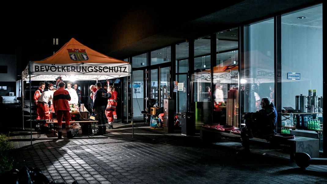 Mitarbeiter:innen des Deutschen Roten Kreuzes und des THW an einer Anlaufstelle für die Bevölkerung beim Stromausfall in Berlin.
