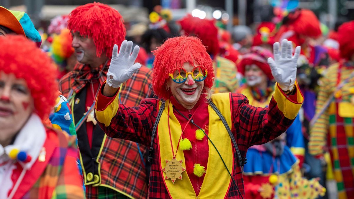 Narren begleiten die Straßenfastnacht mit bunten Kostümen.