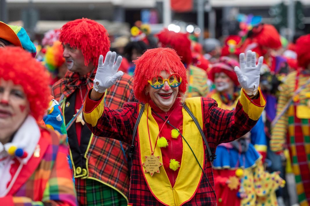 Narren begleiten die Straßenfastnacht mit bunten Kostümen.