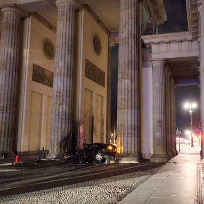 Ein zerstörter PKW liegt zwischen zwei Säulen des Brandenburger Tors.