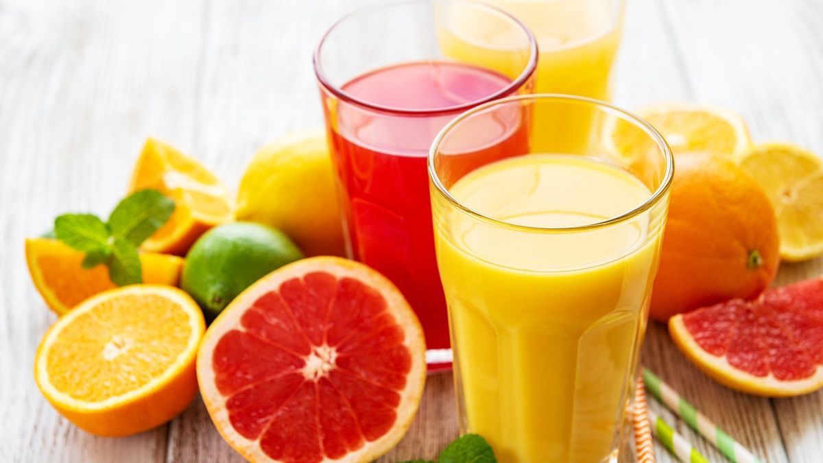 Glasses of juice and citrus fruits