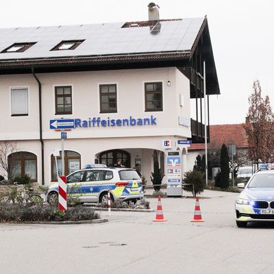 Einsatzkräfte der Polizei stehen nach einem Überfall auf einen Geldtransporter in der Nähe einer Bank in Oberbayern.