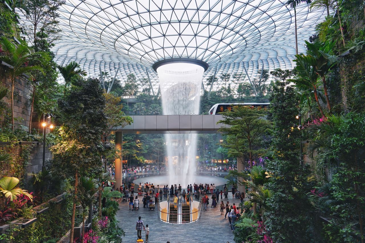 Der Changi International Airport in Singapur ist selbst praktisch ein Urlaubsziel. Er verfügt über eigene Gartenanlagen mitsamt Indoor-Wasserfall, die mehr als einen Besuch wert sind.