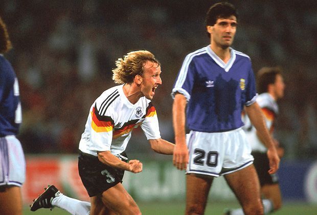 
                <strong>WM 1990</strong><br>
                Ein ganz anderes Trikotdesign gab es 1990 bei der WM in Italien zu bestaunen. Die Leibchen werden gespickt mit den Nationalfarben Schwarz-Rot-Gold - mit Erfolg: Im Finale führt Andreas Brehme (Foto) die DFB-Elf zum dritten WM-Titel.
              