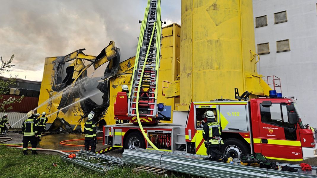 Einsätzkräfte der Feuerwehr löschen eine in Brand geratene Lagerhalle eines Spielzeugherstellers.