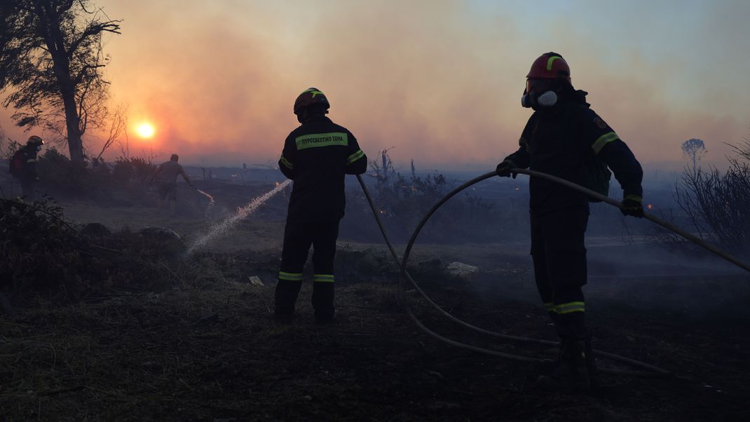 Feuerwehrleute versuchen, einen Flächenbrand im nordwestlichen Vorort Kryoneri zu löschen. 