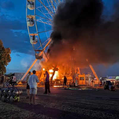 Besucher des Highfield-Festivals blicken auf das Riesenrad, an dem Flammen zu sehen sind.