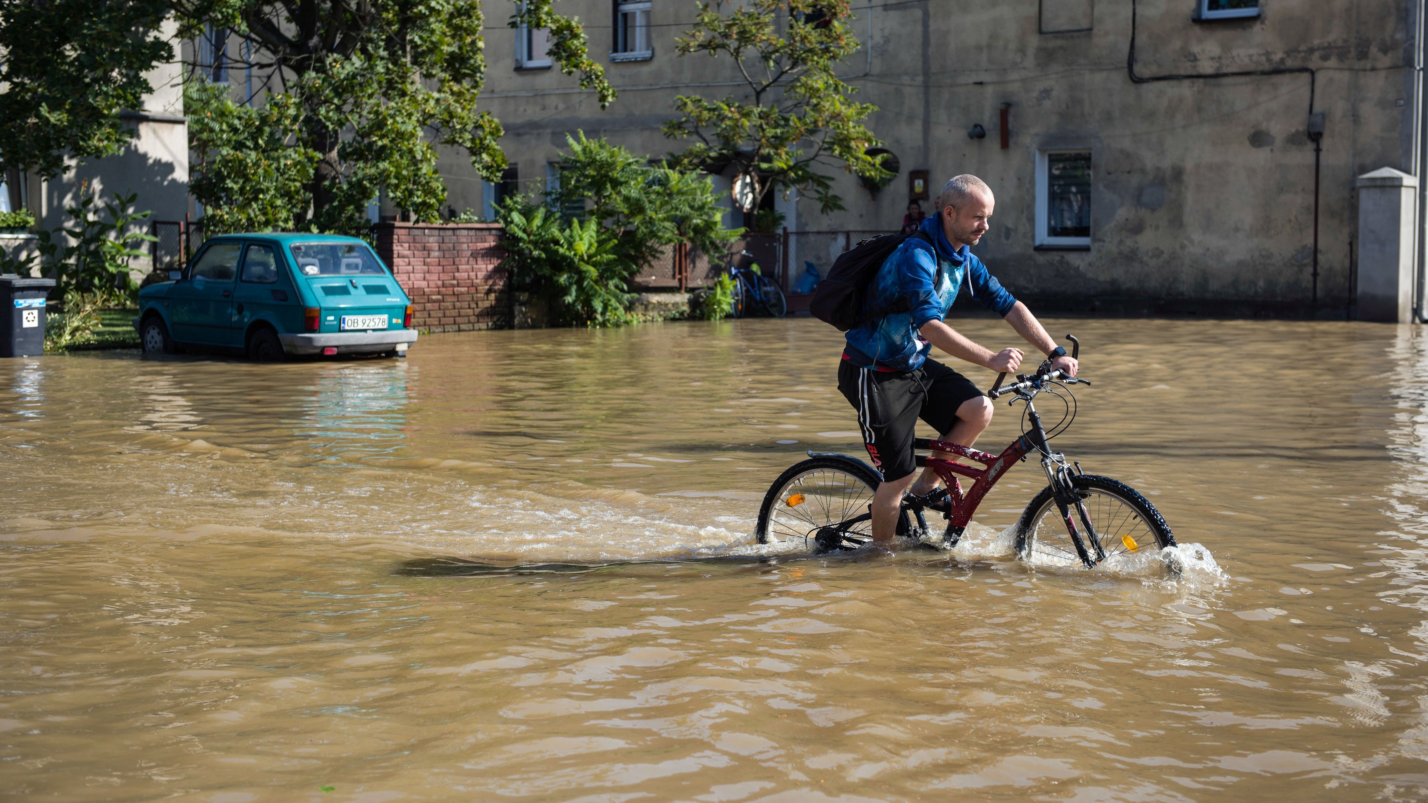 Ein Mann fährt mit dem Fahrrad durch eine überflutete Straße in der Stadt Lewin Brzeski im Süden Polens.