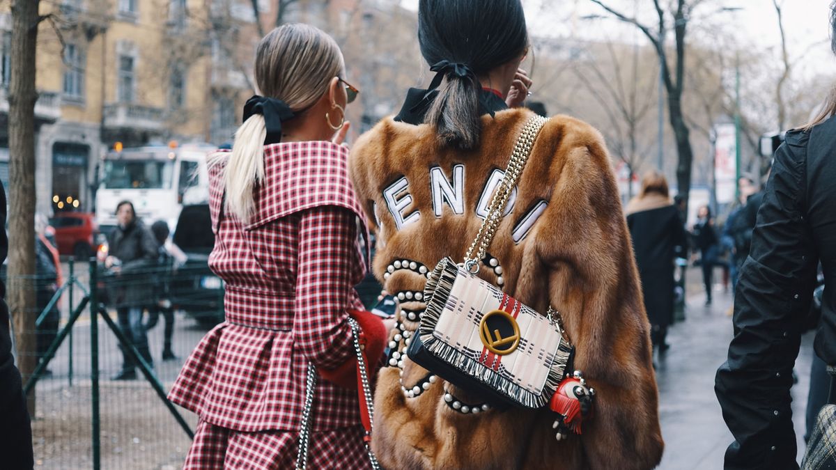 Milan, Italy - February 22, 2018: Fashionable girls wearing Fendi clothing posing after Fendi fashion show during Milan Fashion Week - street style concept