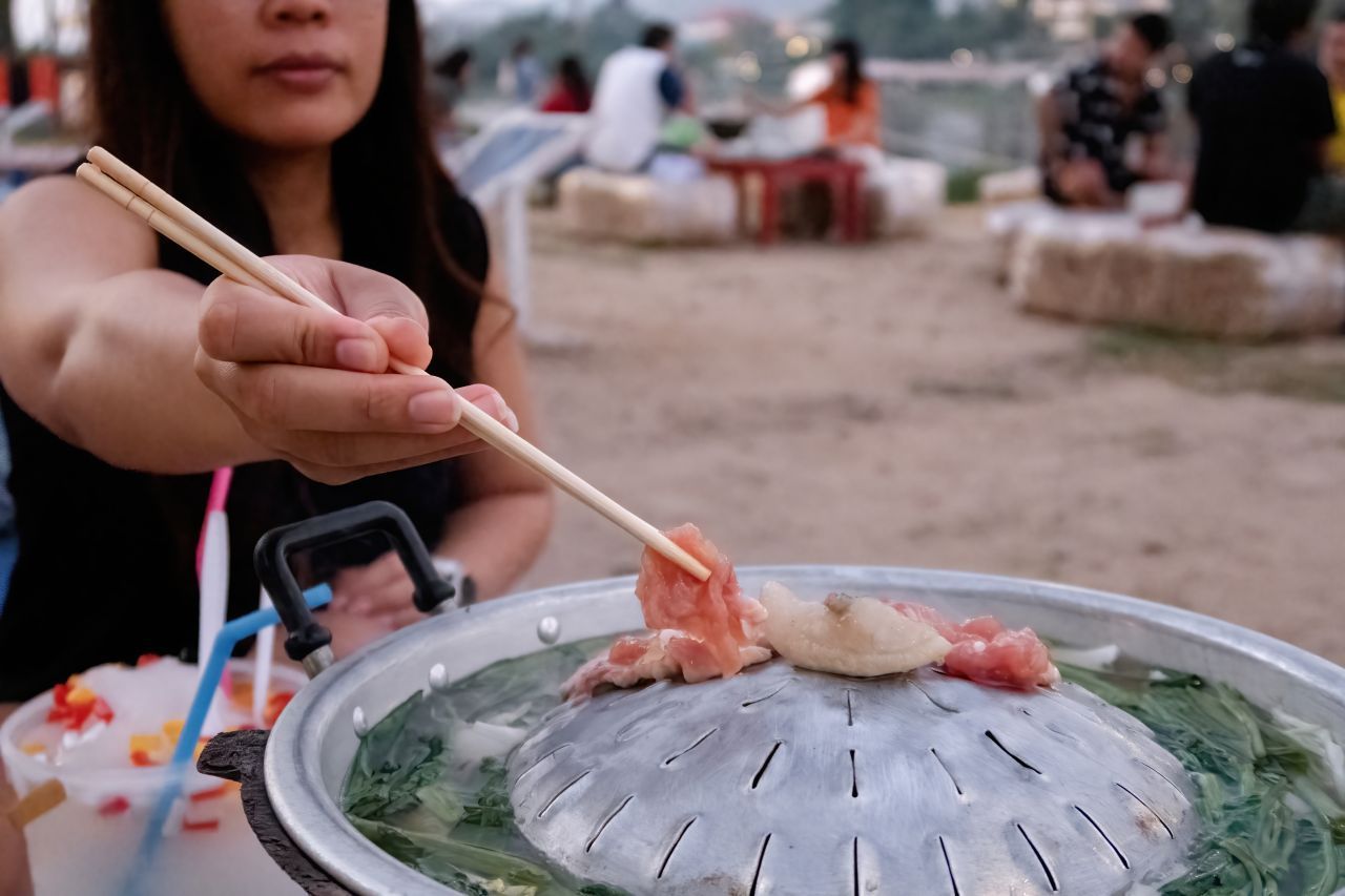 Mu Kratha: Die thailändische Version verwendet eine Kombination aus gewölbtem Grill und Feuertopf mit einer Suppenrinne. Zum Kochen gebracht wird er traditionell mit Kohle.