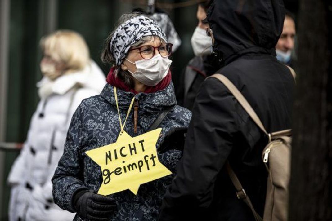 Der gelbe Stern taucht auf Querdenken-Demos immer wieder auf. Ein anderes Beispiel: Eine Querdenkerin, die sich auf einer Kundgebung mit Anne Frank verglich.