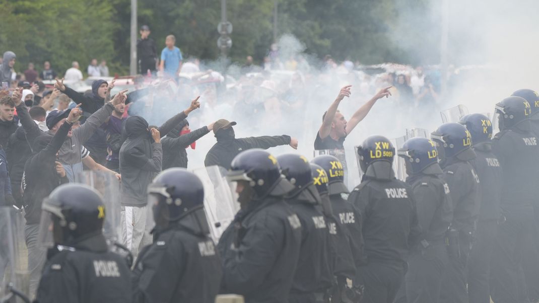 4. August 2024, Großbritannien, Rotherham: Polizisten stehen vor Randalierern bei gewalttätigen Auseinandersetzungen auf einer Anti-Einwanderungsdemonstration vor dem Holiday Inn Express Hotel, in dem Asylbewerber:innen untergebracht sind. 