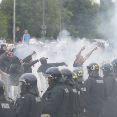 4. August 2024, Großbritannien, Rotherham: Polizisten stehen vor Randalierern bei gewalttätigen Auseinandersetzungen an einem Hotel, in dem Asylbewerber:innen untergebracht sind. 