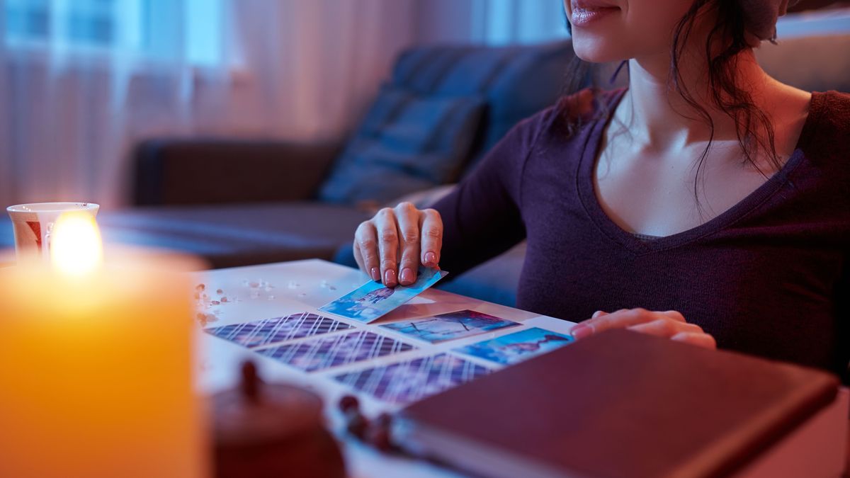 Dark-haired Caucasian soothsayer laying out Tarot cards