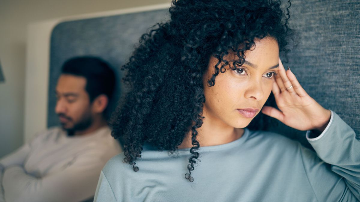 Couple, fight and stress in bedroom for divorce, anger and thinking of breakup, cheating and anxiety. Face of frustrated, sad and depressed woman with partner in bed for conflict, argument and drama