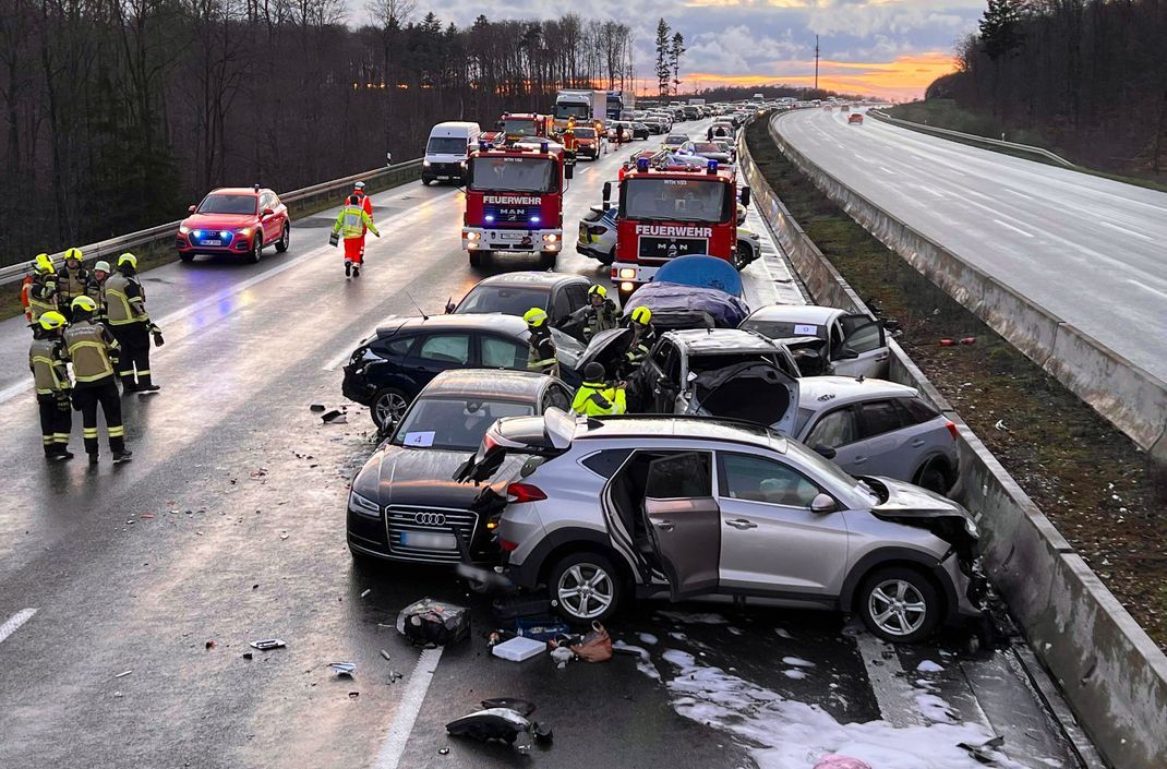 Mehrere Fahrzeuge stehen nach einer Massenkarambolage auf der A3 in der Nähe von Würzburg an der Unfallstelle.