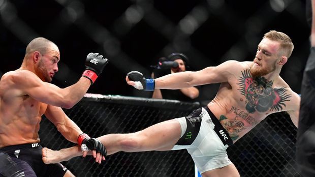 
                <strong>Conor McGregor vs. Eddie Alvarez, UFC 205, 12.11.2016</strong><br>
                Bei UFC 205 schrieb McGregor Geschichte: Als amtierender Weltmeister im Federgewicht besiegte er Eddie Alvarez, den Weltmeister im Leichtgewicht, in der zweiten Runde durch T.K.o. Somit hielt der Ire als erster UFC-Kämpfer gleichzeitig die WM-Titel zweier Gewichtsklassen.
              