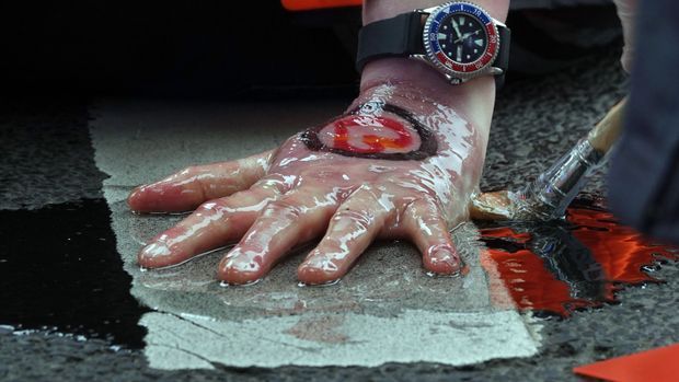 Polizisten lösen die festgeklebte Hand eines Aktivisten der Letzten Generation