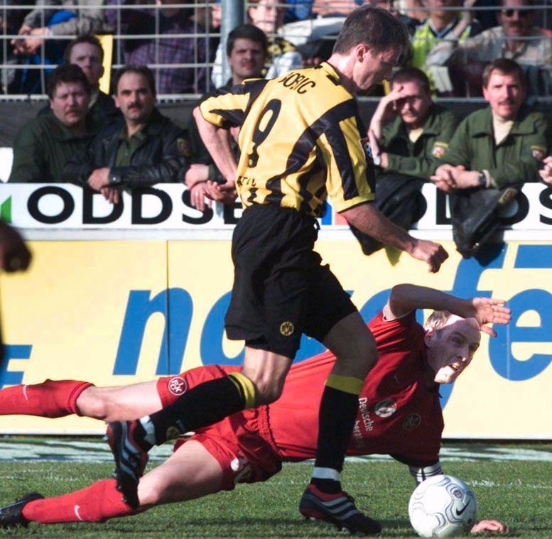 
                <strong>Fredi Bobic</strong><br>
                Na, wer versucht sich da als Towart? Genau, es ist Mario Basler. Hier im Zweikampf mit Fredi Bobic. Beim Jahrhundertspiel sind beide allerdings in einem gemeinsamen Team
              