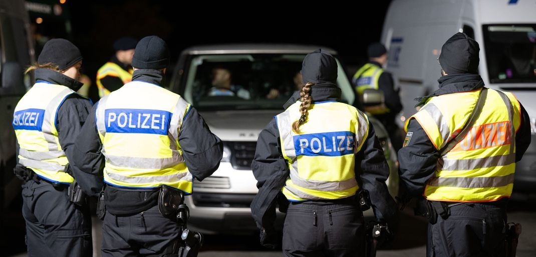 Polizisten stehen anlässlich von Grenzkontrollen auf dem Rastplatz "Am Heideholz" an der Autobahn 17 nahe der deutsch-tschechischen Grenze.